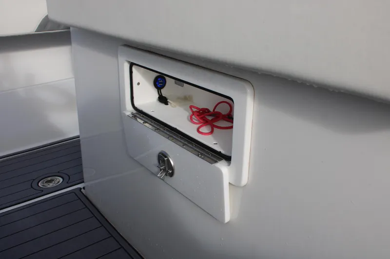 Slide: The Image of 2023 Front Runner 33 Center Console boat storage compartment with red cords. - 10