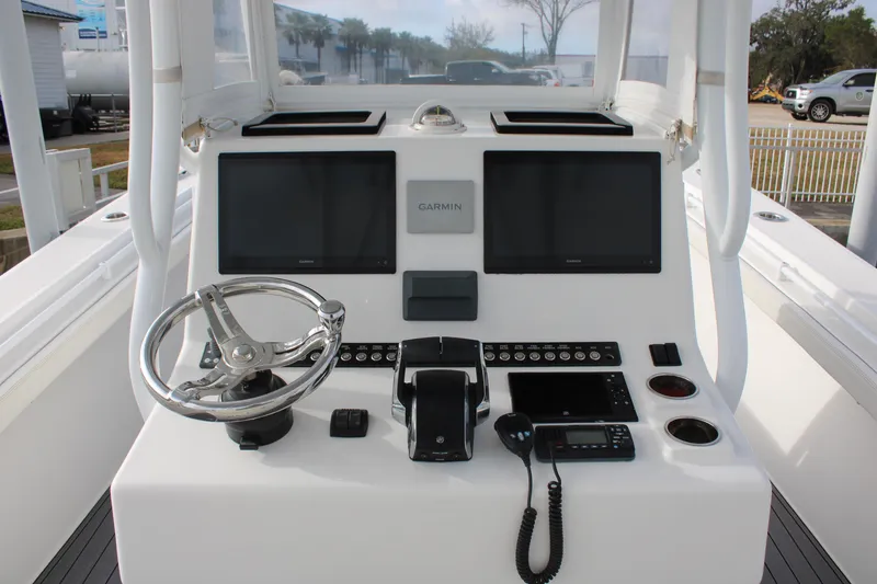 Slide: The Image of 2023 Front Runner 33 Center Console boat dashboard with dual screens and steering wheel. - 44