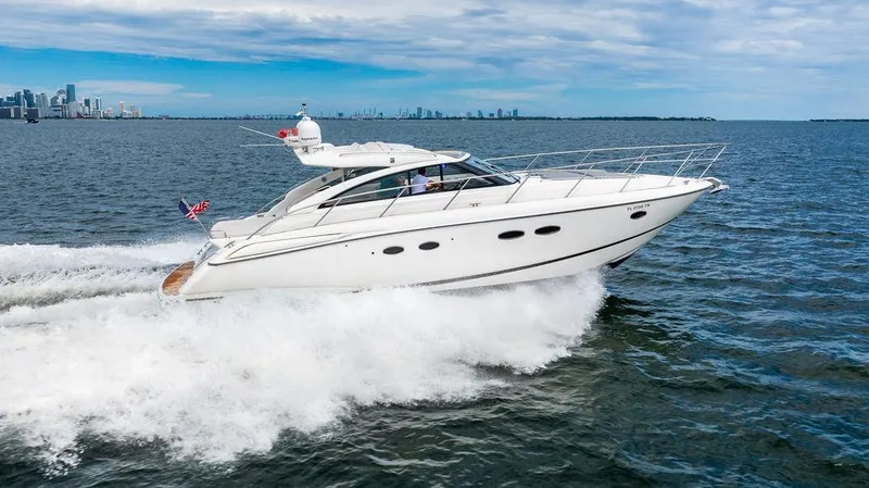Slide: The Image of 2012 Princess V45 yacht cruising on open water with city skyline in background. - 11