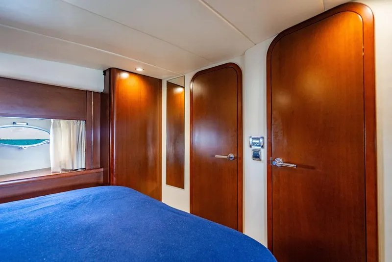 Slide: The Image of Luxurious cabin interior of 2012 Princess V45 yacht with wooden doors and blue bedding. - 30