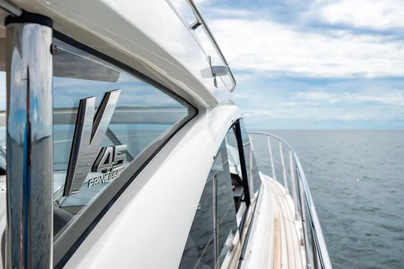 Slide: The Image of 2012 Princess V45 yacht cruising on open sea under clear skies. - 35