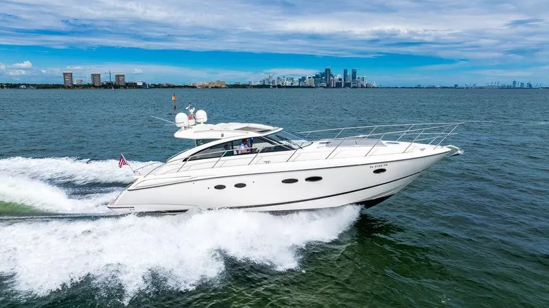 Slide: The Image of 2012 Princess V45 yacht cruising on open water with city skyline in background. - 5