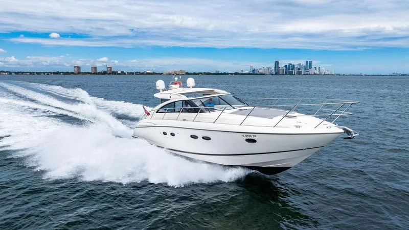 Slide: The Image of 2012 Princess V45 yacht cruising on open water with city skyline in background. - 9