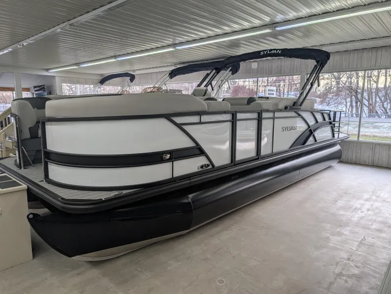 The Image of 2025 Sylvan L3 DLZ Bar pontoon boat in showroom, featuring sleek design and modern amenities. - 0