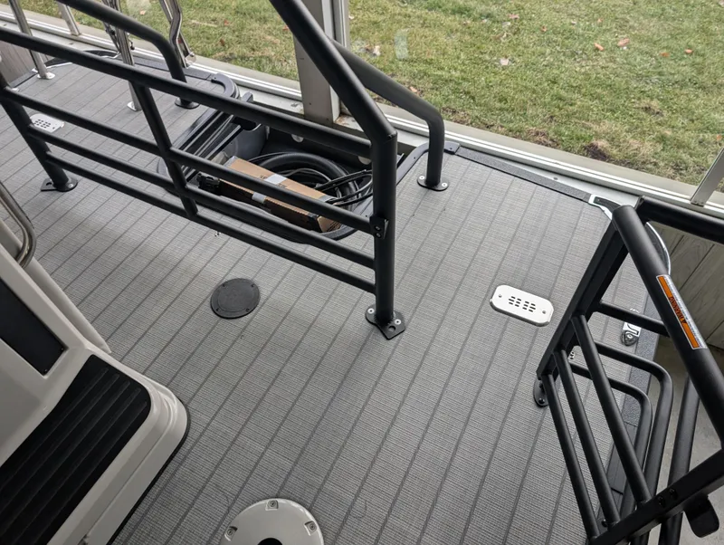 Slide: The Image of 2025 Sylvan L3 DLZ Bar boat deck with safety rails and storage compartment. - 10