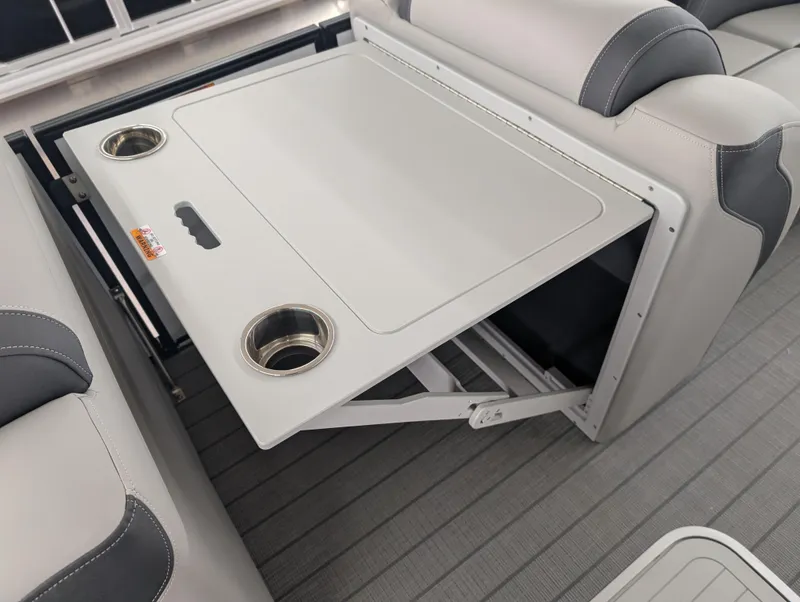 Slide: The Image of Sylvan L3 DLZ Bar 2025 boat interior with foldable table and cup holders. - 14