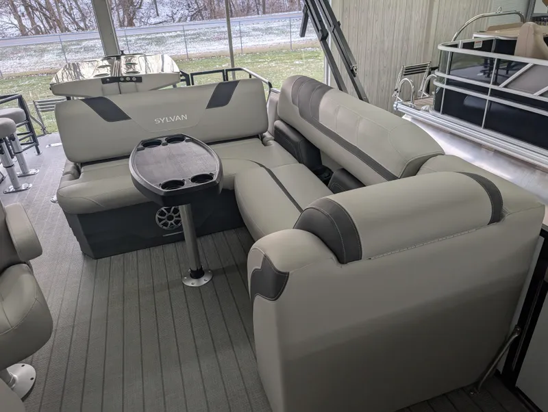 Slide: The Image of 2025 Sylvan L3 DLZ Bar pontoon boat interior with plush seating and table. - 5