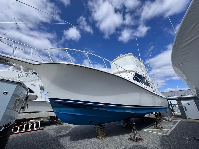 Slide: The Image of 2011 Henriques 42 Sportfisherman boat on stands, blue hull, cloudy sky background. - 15