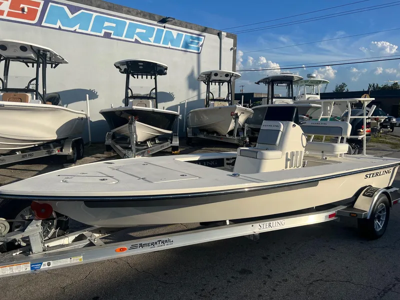 Slide: The Image of 2023 Sterling 180TS boat on trailer at dealership, surrounded by other boats. - 3