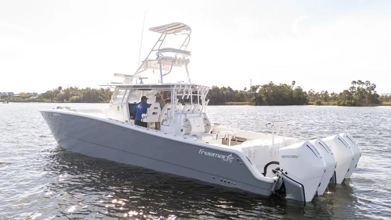 Slide: The Image of 2023 Freeman 42 LR boat on water with triple outboard engines. - 32