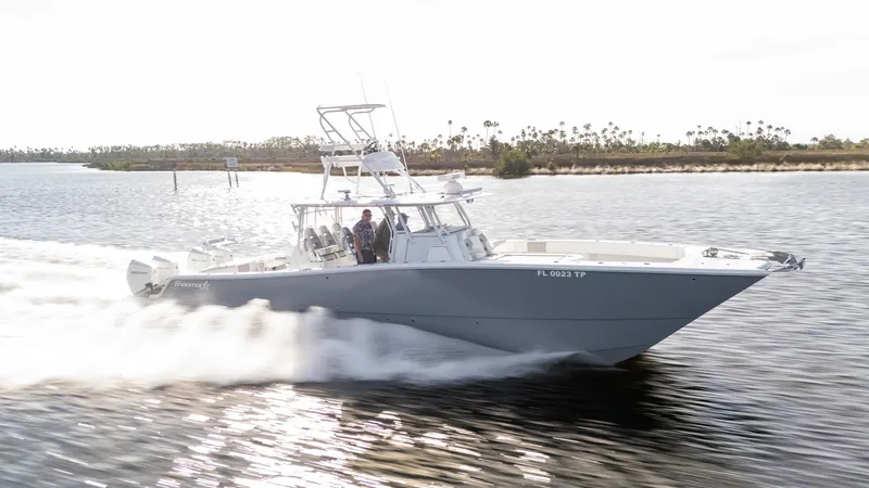 Slide: The Image of 2023 Freeman 42 LR boat speeding on a calm waterway. - 35