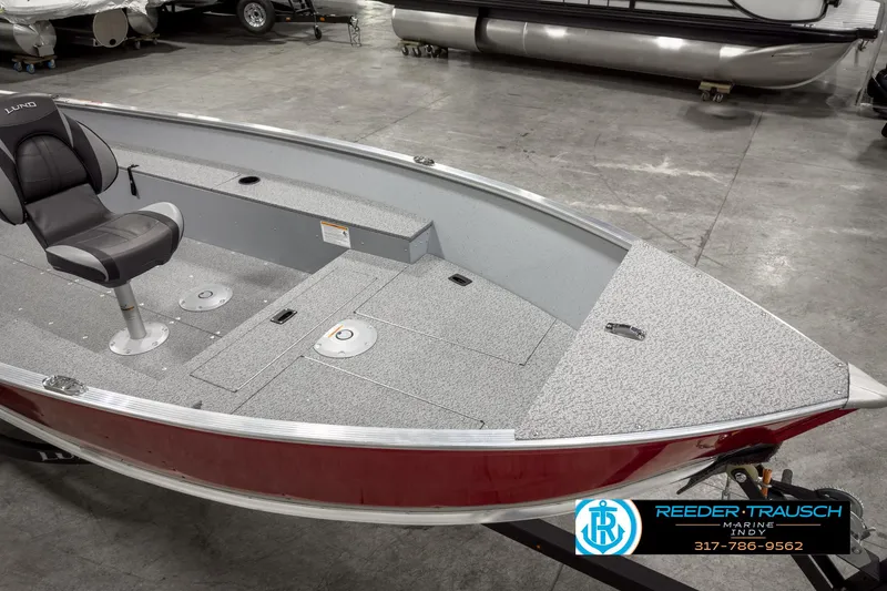 Slide: The Image of 2025 Lund 1600 Fury Heritage Edition boat with red exterior and gray interior, displayed indoors. - 8