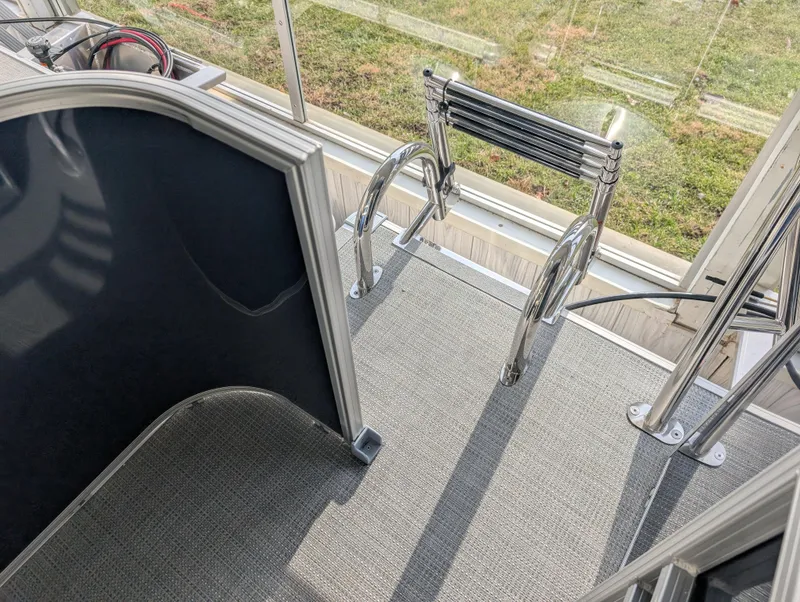 Slide: The Image of 2025 Sylvan Mirage Fish 8520 Party Fish boat interior with ladder and carpeted floor. - 10