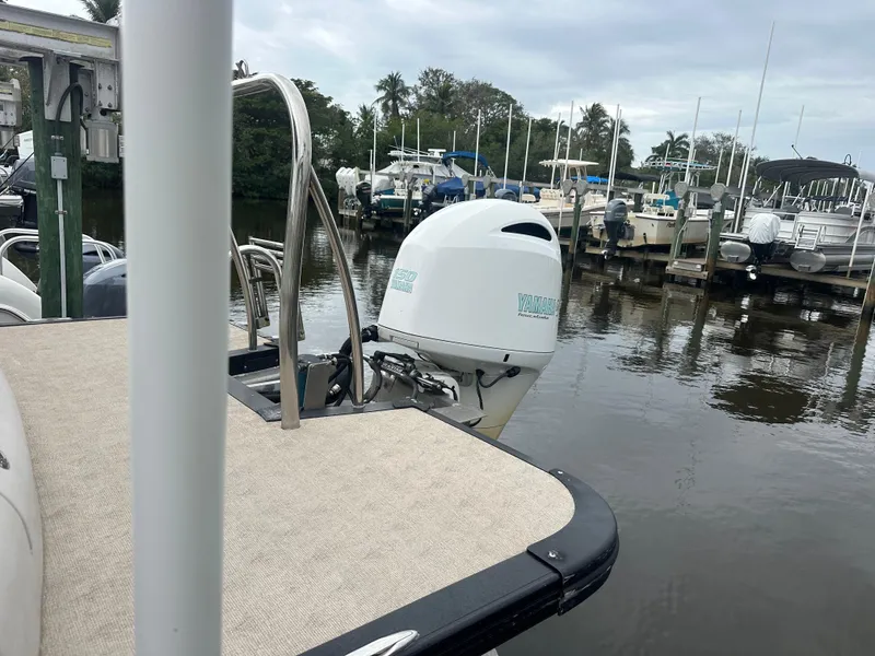 Slide: The Image of 2017 Avalon Catalina Rear J Lounger boat docked at marina with outboard motor. - 4