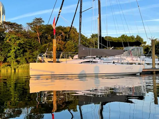 Slide: The Image of 2021 J Boats J 88 sailboat docked on calm water at sunset. - 0