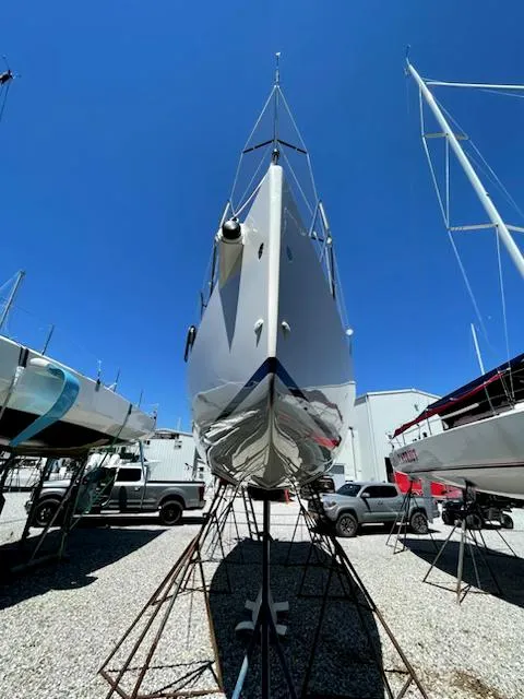 Slide: The Image of 2021 J Boats J 88 sailboat on stands, viewed from the front under a clear blue sky. - 8