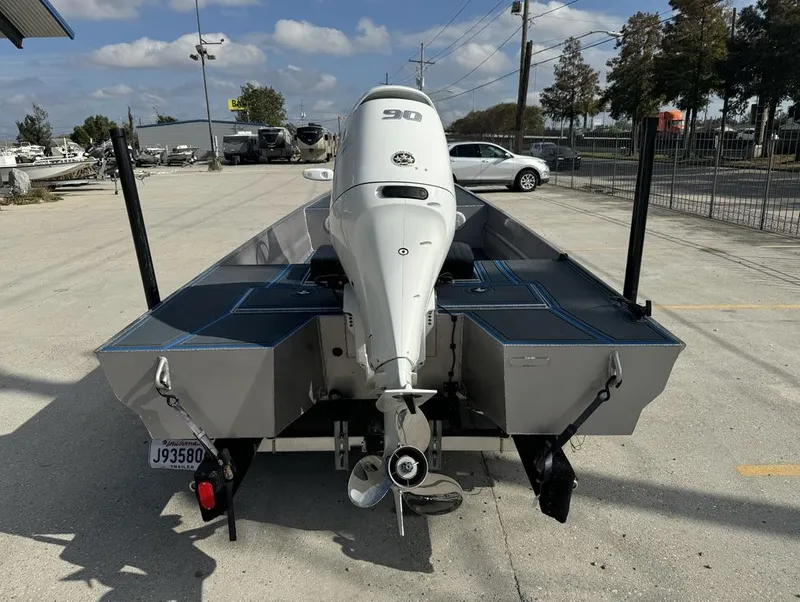 Slide: The Image of Custom Cottonmouth 1860 boat, 2022 model, with a 90 HP outboard motor, parked outdoors. - 12