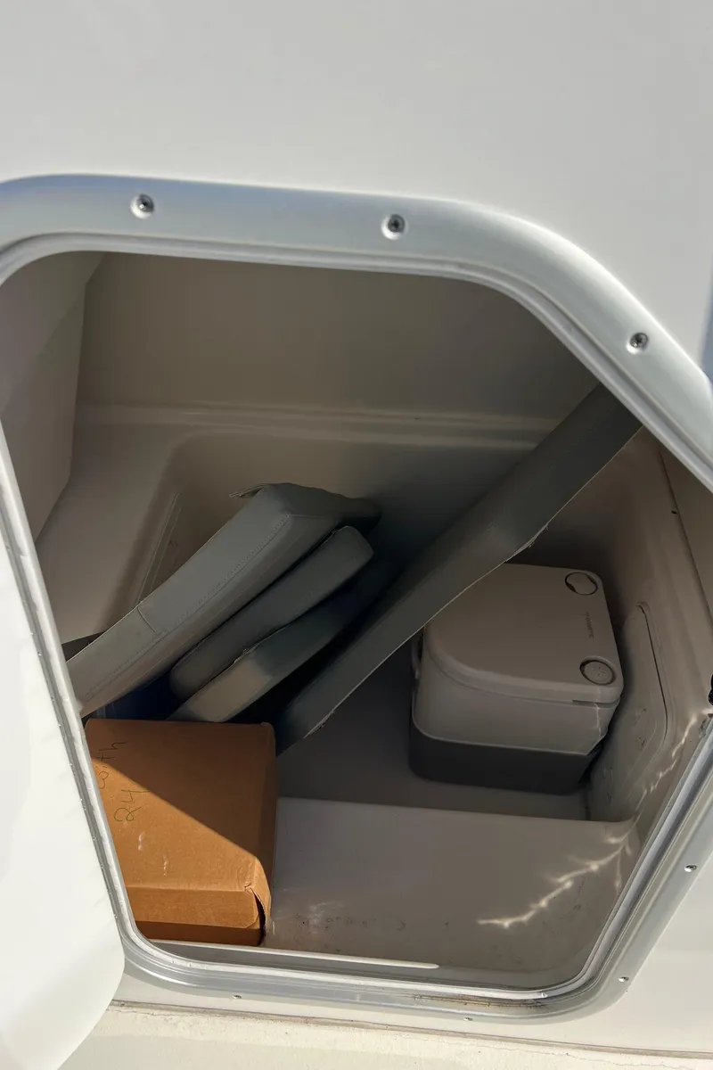 Slide: The Image of Storage compartment in 2024 Cape Horn 24XS boat with cushions and a portable toilet. - 6