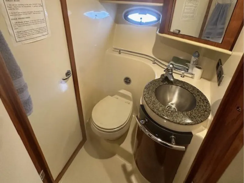 Slide: The Image of 2005 Sea Ray 390 Sundancer bathroom with sink, toilet, and porthole window. - 11