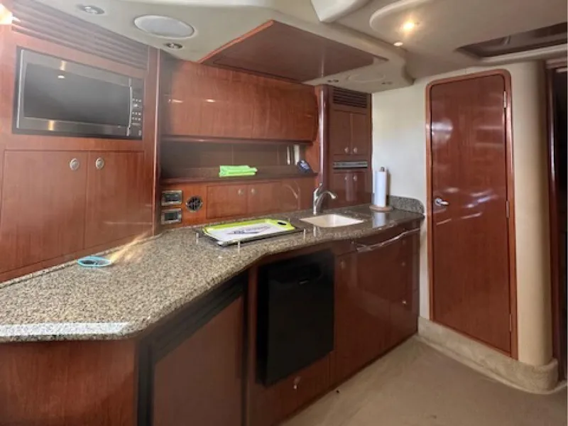 Slide: The Image of Interior of 2005 Sea Ray 390 Sundancer yacht with modern kitchen amenities. - 9