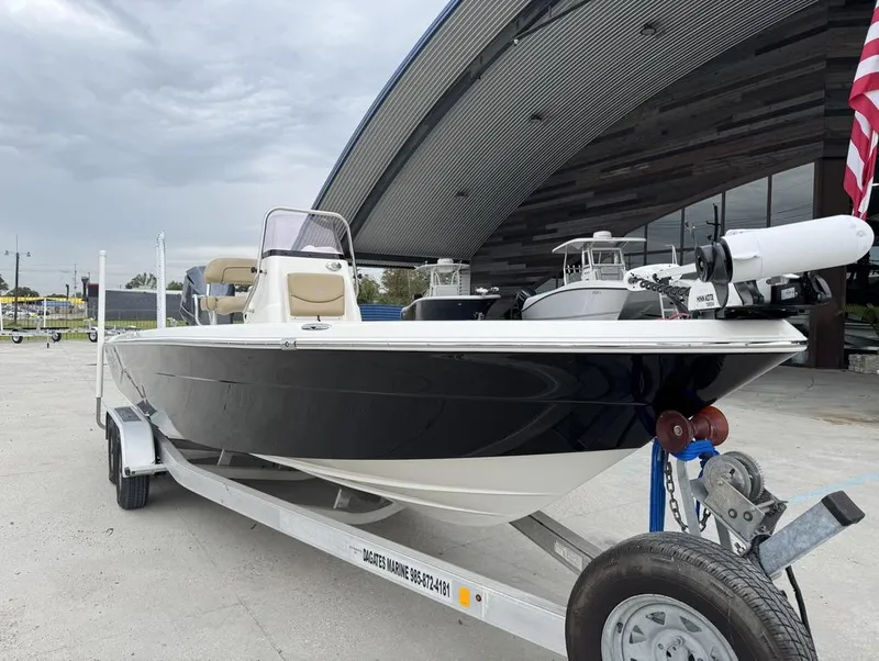 Slide: The Image of 2019 NauticStar 244 XTS boat on trailer, parked outside modern building. - 13