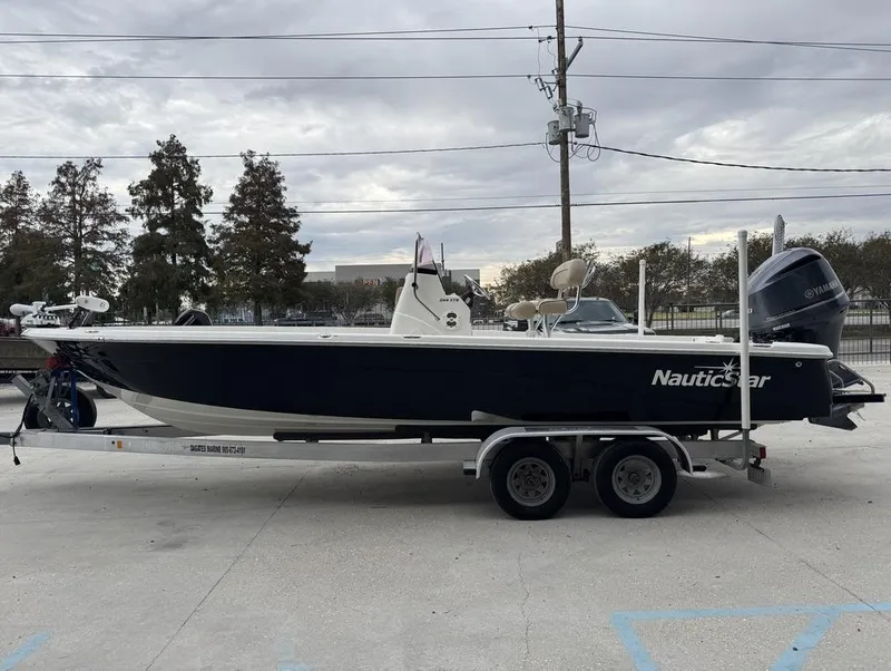 Slide: The Image of 2019 NauticStar 244 XTS boat on trailer, parked outdoors. - 3