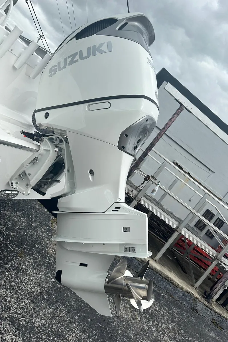 Slide: The Image of 2024 Cape Horn 22OS with Suzuki outboard motor, parked outdoors. - 10