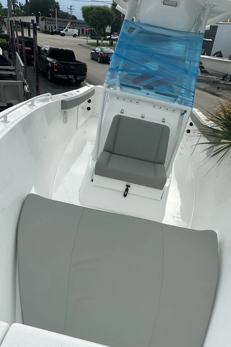 Slide: The Image of 2024 Cape Horn 22OS boat interior with seating and console, docked outdoors. - 6