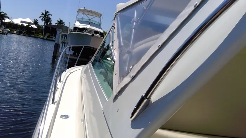 Slide: The Image of 1993 Tiara Yachts 3100 Open docked by a serene waterfront. - 18