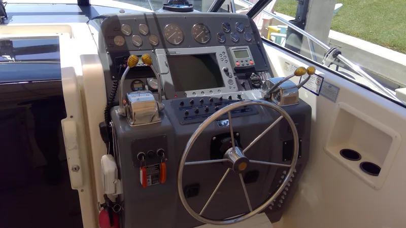 Slide: The Image of 1993 Tiara Yachts 3100 Open helm with steering wheel and navigation controls. - 24