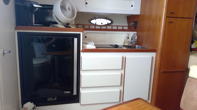 Slide: The Image of 1993 Tiara Yachts 3100 Open cabin kitchen with fridge, sink, and storage cabinets. - 33