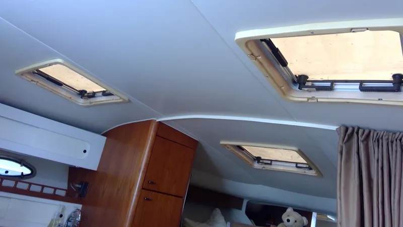 Slide: The Image of Interior cabin of 1993 Tiara Yachts 3100 Open with wooden cabinets and portholes. - 34