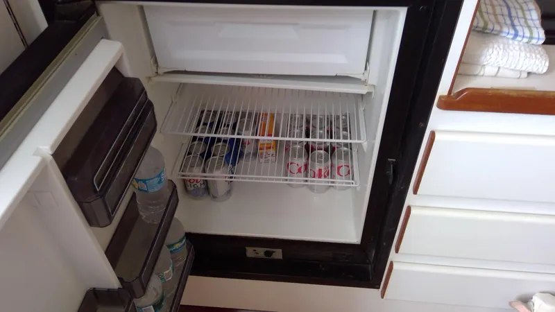 Slide: The Image of Refrigerator inside 1993 Tiara Yachts 3100 Open, stocked with drinks and water bottles. - 38