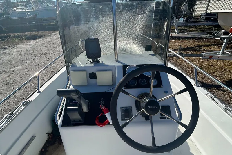 Slide: The Image of 1995 Boston Whaler Dauntless 15 boat console with steering wheel and controls. - 5