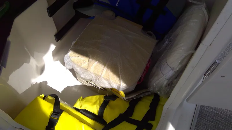 Slide: The Image of Storage compartment in 2017 Starcraft SCX 240 boat with life jackets and cushions. - 14