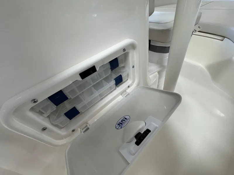 Slide: The Image of 2025 Boston Whaler 190 Montauk storage compartment detail, open lid, white interior. - 8