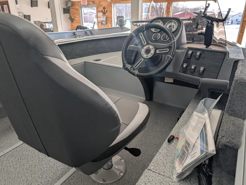 Slide: The Image of Interior of 2023 Starcraft Stealth 16 SC boat with steering wheel and control panel. - 2