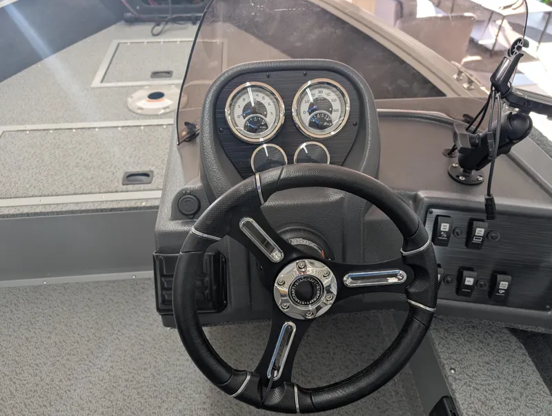 Slide: The Image of 2023 Starcraft Stealth 16 SC boat dashboard with steering wheel and gauges. - 5