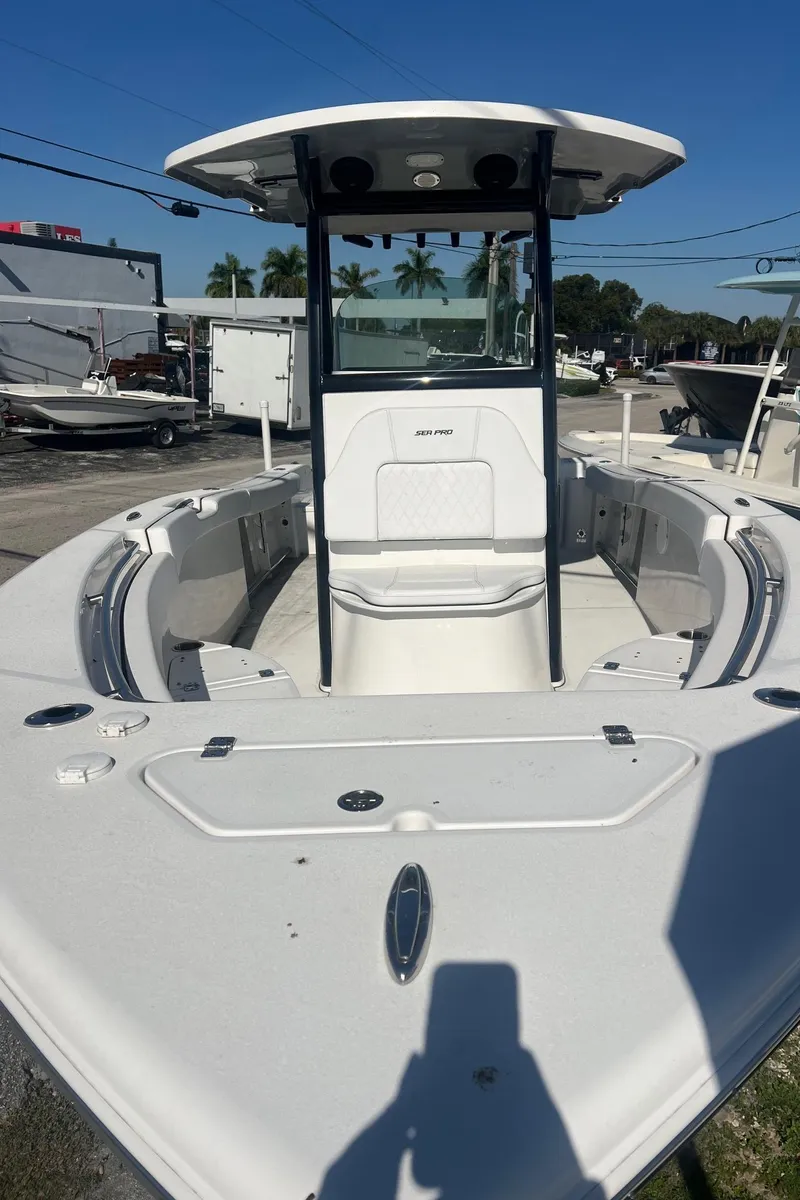Slide: The Image of 2024 Sea Pro 242 DLX boat, white deck, center console, outdoor display. - 4