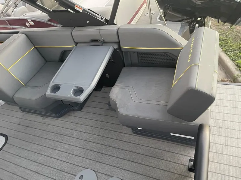 Slide: The Image of 2024 Manitou Explorer 24 boat interior with gray seating and table. - 10