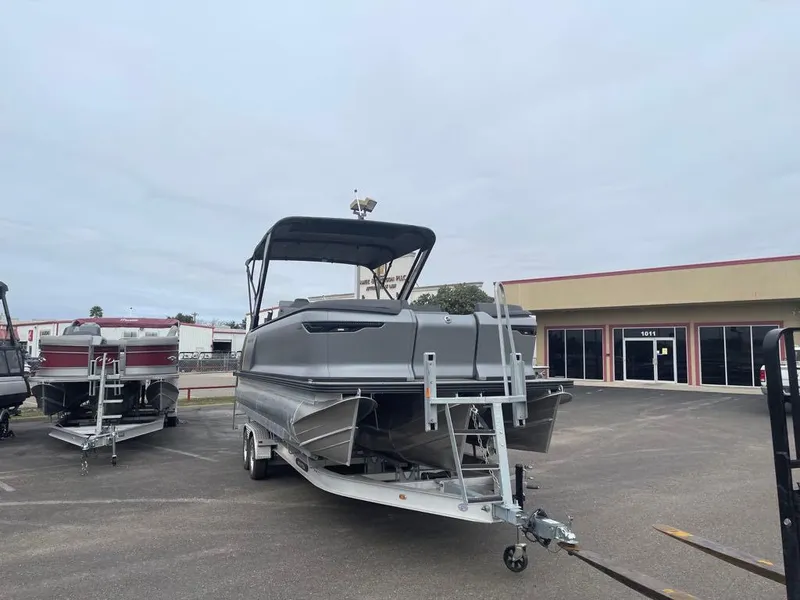 Slide: The Image of 2024 Manitou Explorer 24 pontoon boat on trailer in parking lot. - 3