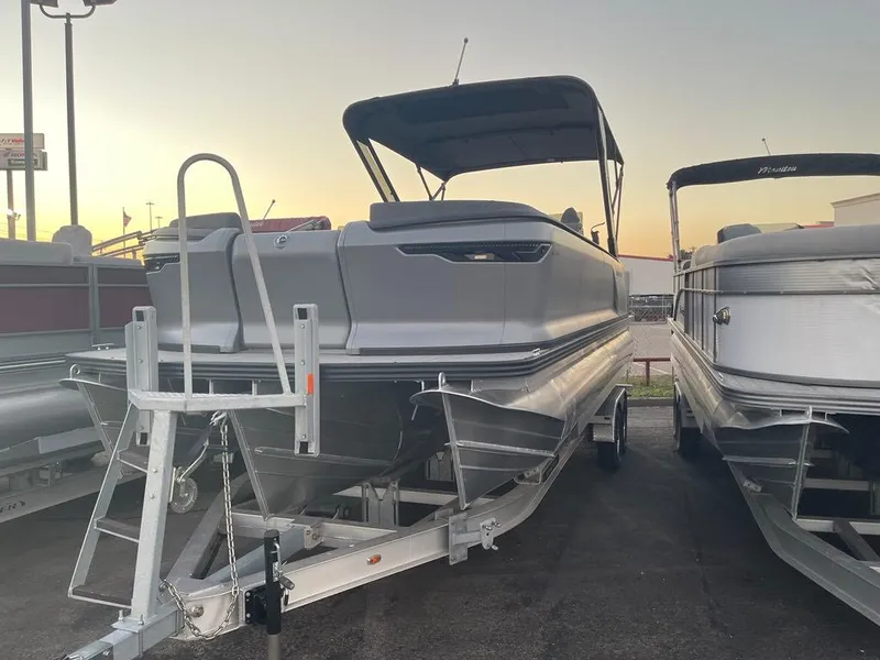 Slide: The Image of 2024 Manitou Explorer 24 pontoon boat on trailer at sunset. - 4