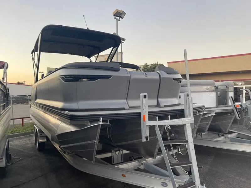 Slide: The Image of 2024 Manitou Explorer 24 pontoon boat on trailer at dealership. - 5