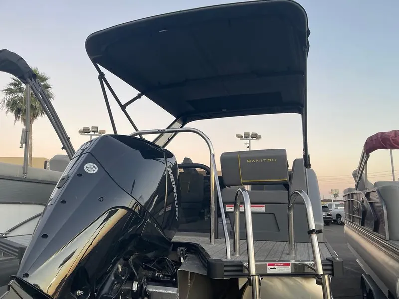 Slide: The Image of 2024 Manitou Explorer 24 pontoon boat with outboard motor and canopy. - 6