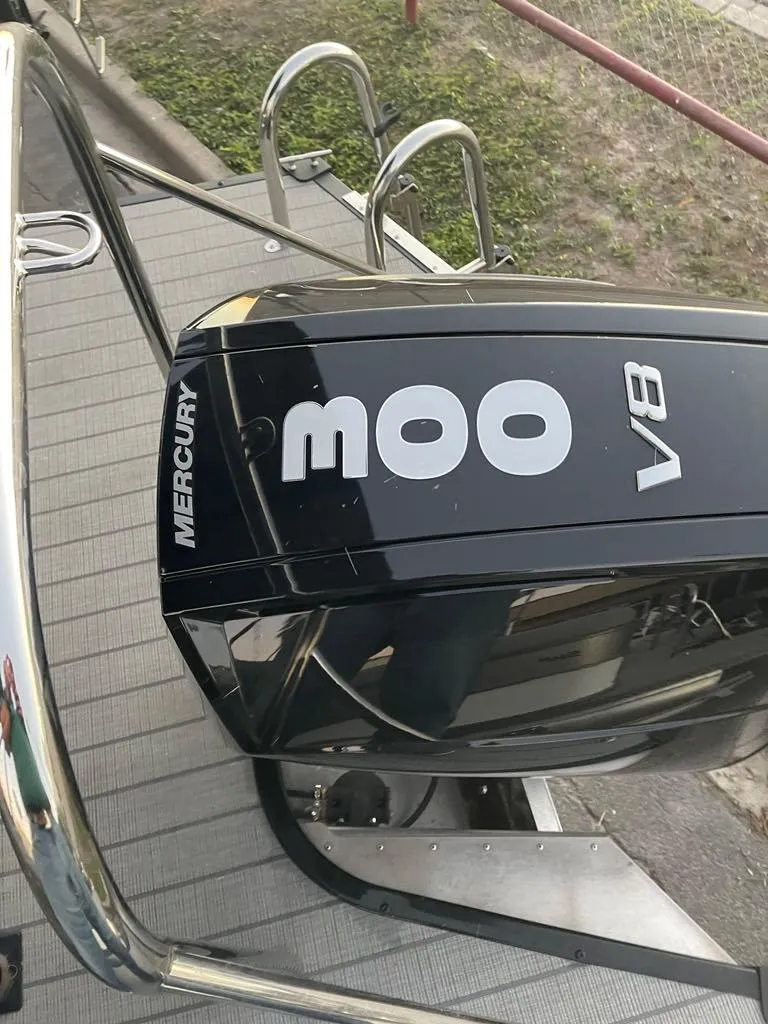 Slide: The Image of 2024 Manitou Explorer 24 with Mercury V8 engine on a boat deck. - 9