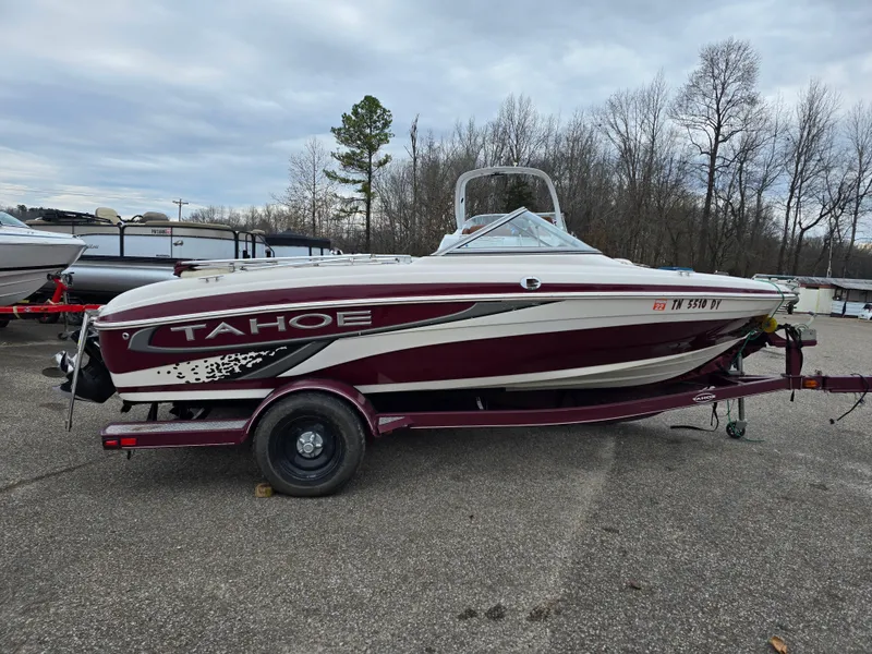 The Image of 2009 Tahoe Q4 SS boat on trailer, parked outdoors with trees in background. - 0