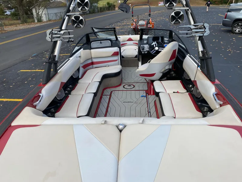 Slide: The Image of 2016 Malibu Wakesetter 23 LSV interior with red and white seating, speakers, and steering console. - 12