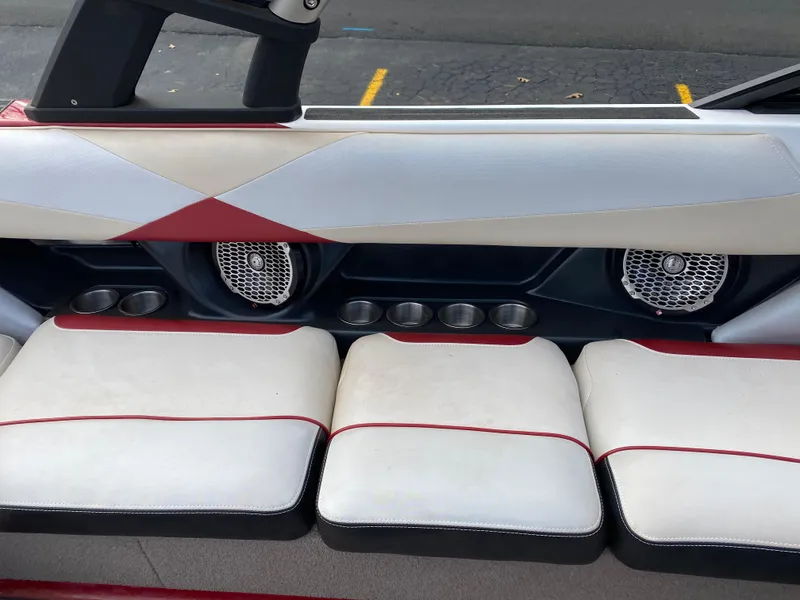 Slide: The Image of 2016 Malibu Wakesetter 23 LSV interior with white and red seating, speakers, and cup holders. - 21