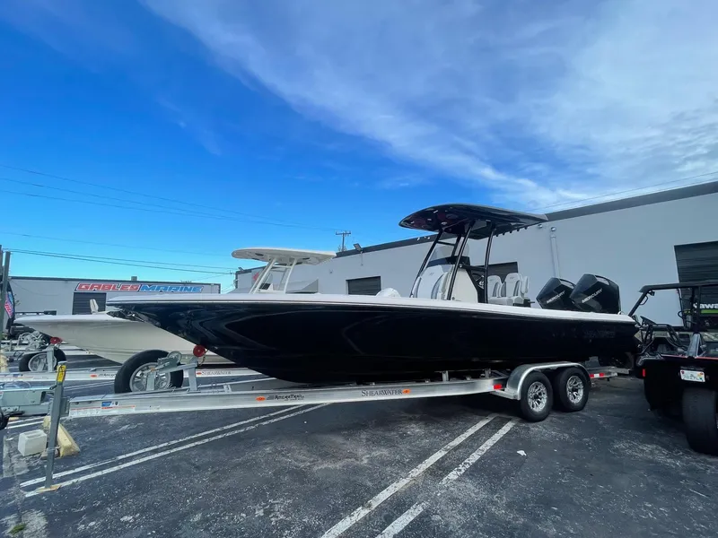 The Image of 2024 ShearWater 270 SS Carolina boat on trailer, parked outdoors under blue sky. - 1