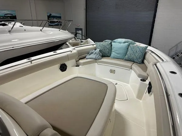 Slide: The Image of 2022 Boston Whaler 330 Outrage boat interior with cushioned seating and decorative pillows. - 10